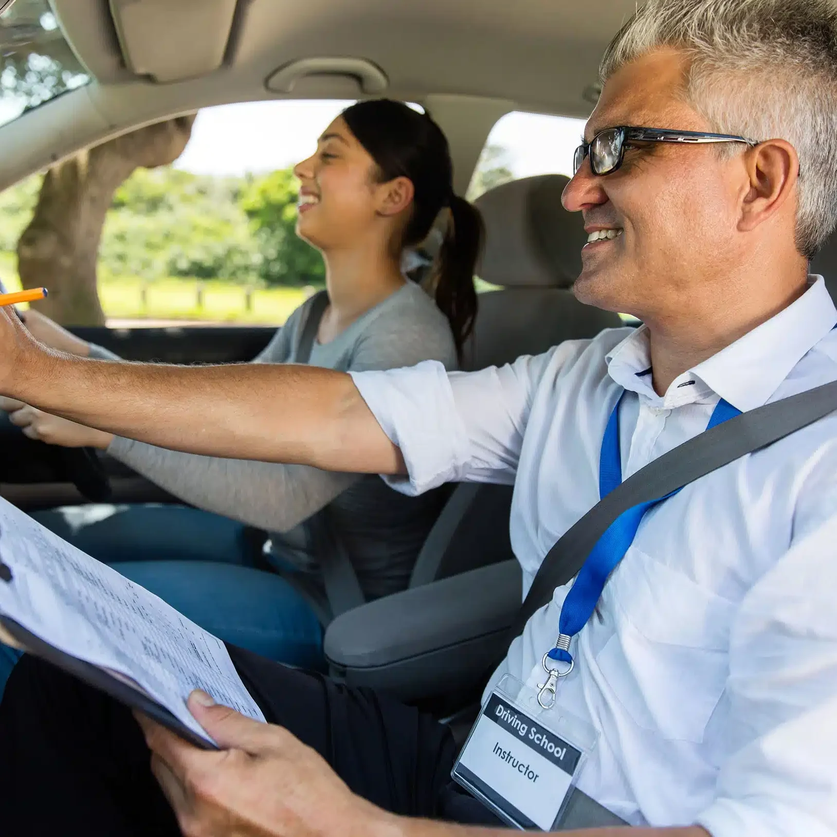driving instructor guiding student to drive